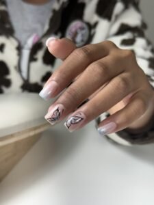 Hand with glitter butterfly nail design and russian manicure in Tampa, Florida.