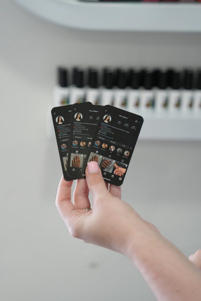 Hand holding cards with nail studio Instagram profile, promoting russian manicure near me in Tampa.