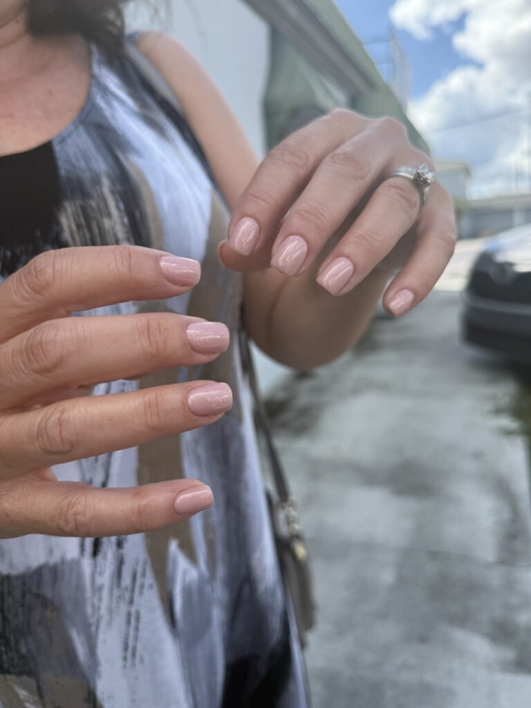 Natural nude nails glowing after russian manicure in Tampa, Florida sunlight.
