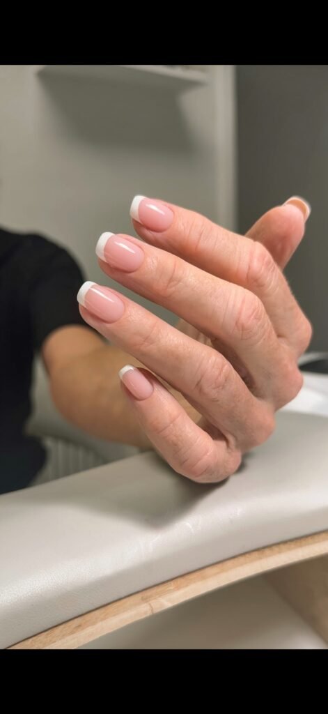 Hand with clean French tips after a russian manicure in Tampa.