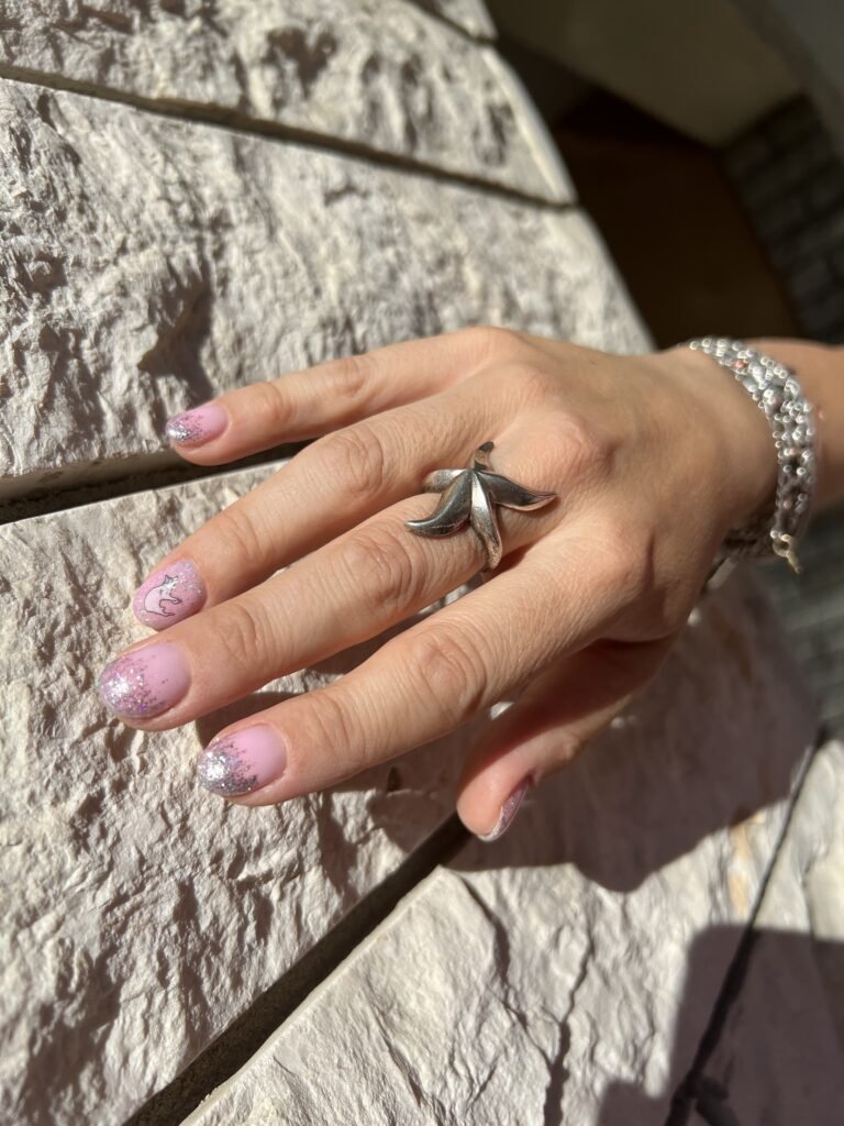Soft pink glitter nails after a russian manicure in Tampa, Florida sunlight.