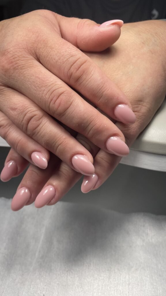 Close-up of soft nude glossy nails after a russian manicure near me in Tampa, Florida.