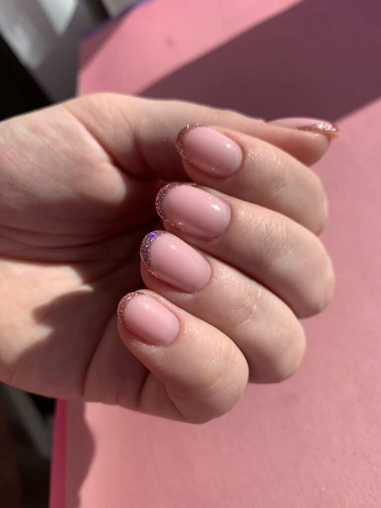 Soft pink nails with glitter French tips after a russian manicure near me in Tampa, Florida.