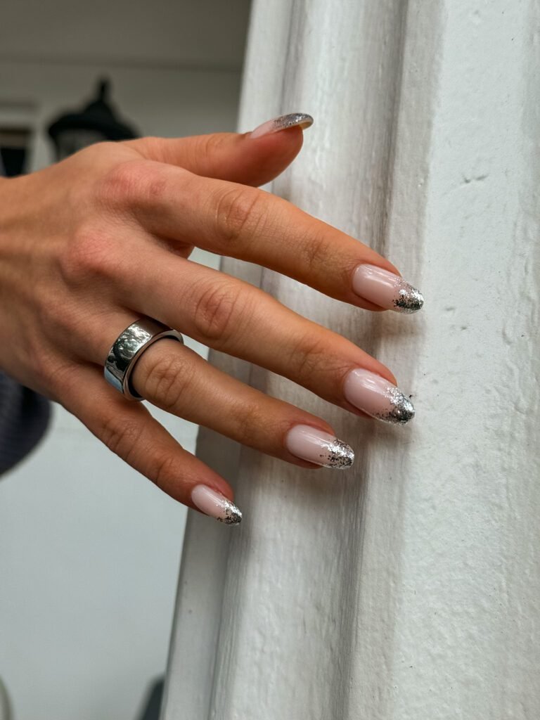 Hands with elegant russian manicure in Tampa, Florida, soft pink polish and metallic tips.