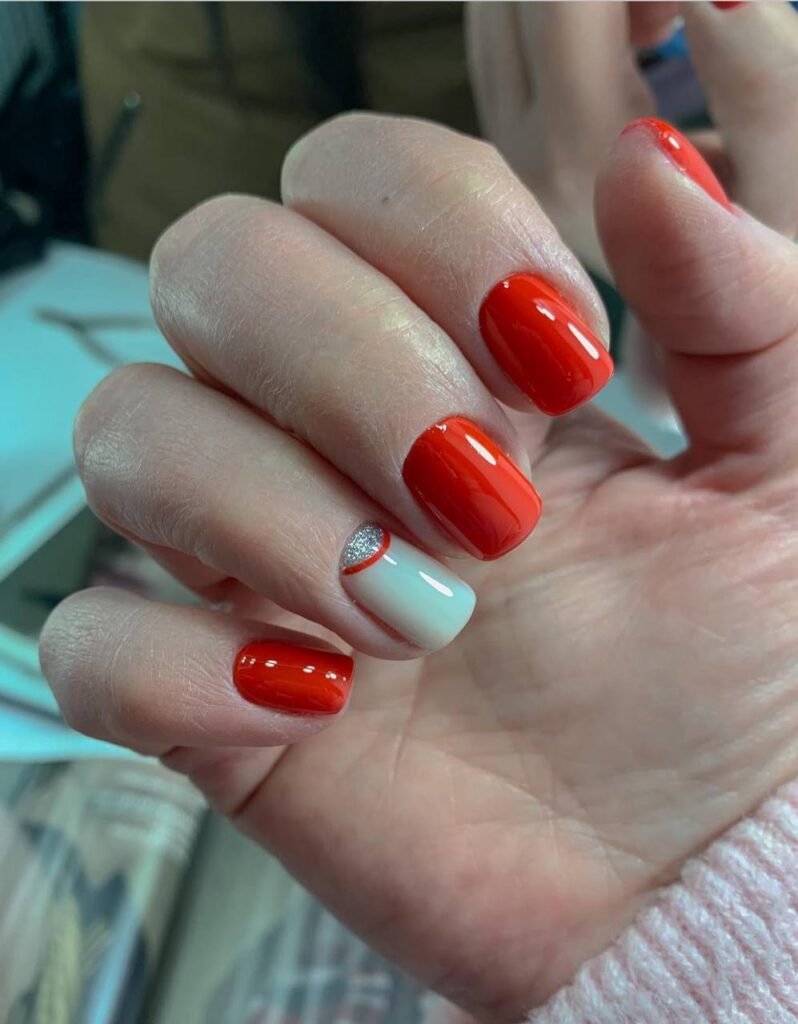 Close-up of glossy builder gel manicure with red and white Russian nails in Tampa, Florida.