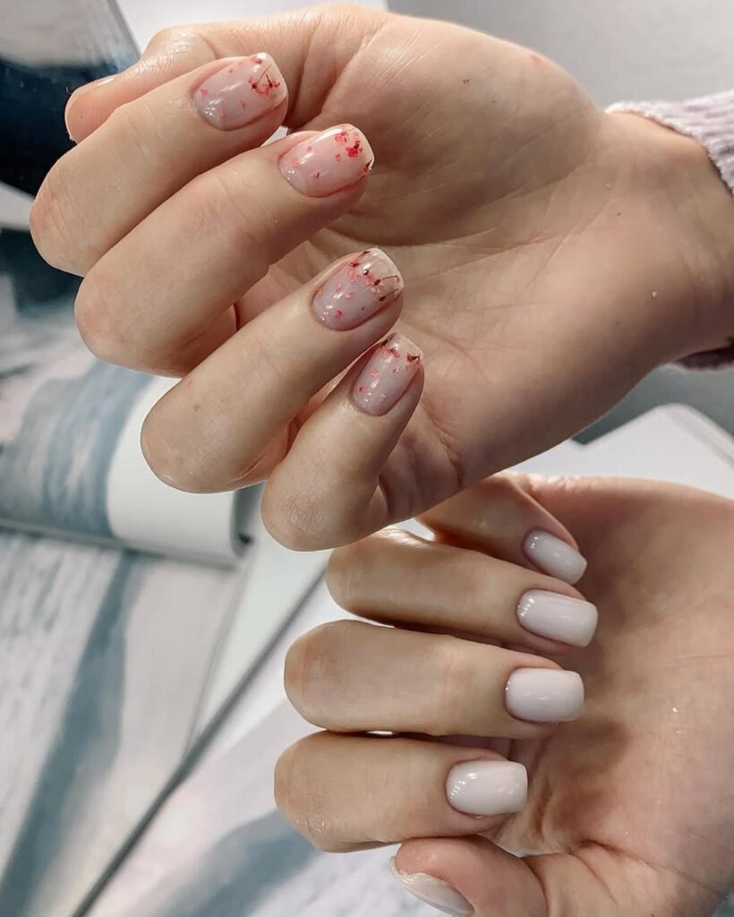 Hands with soft neutral nails featuring delicate flakes, created using hard gel russian manicure in Tampa.