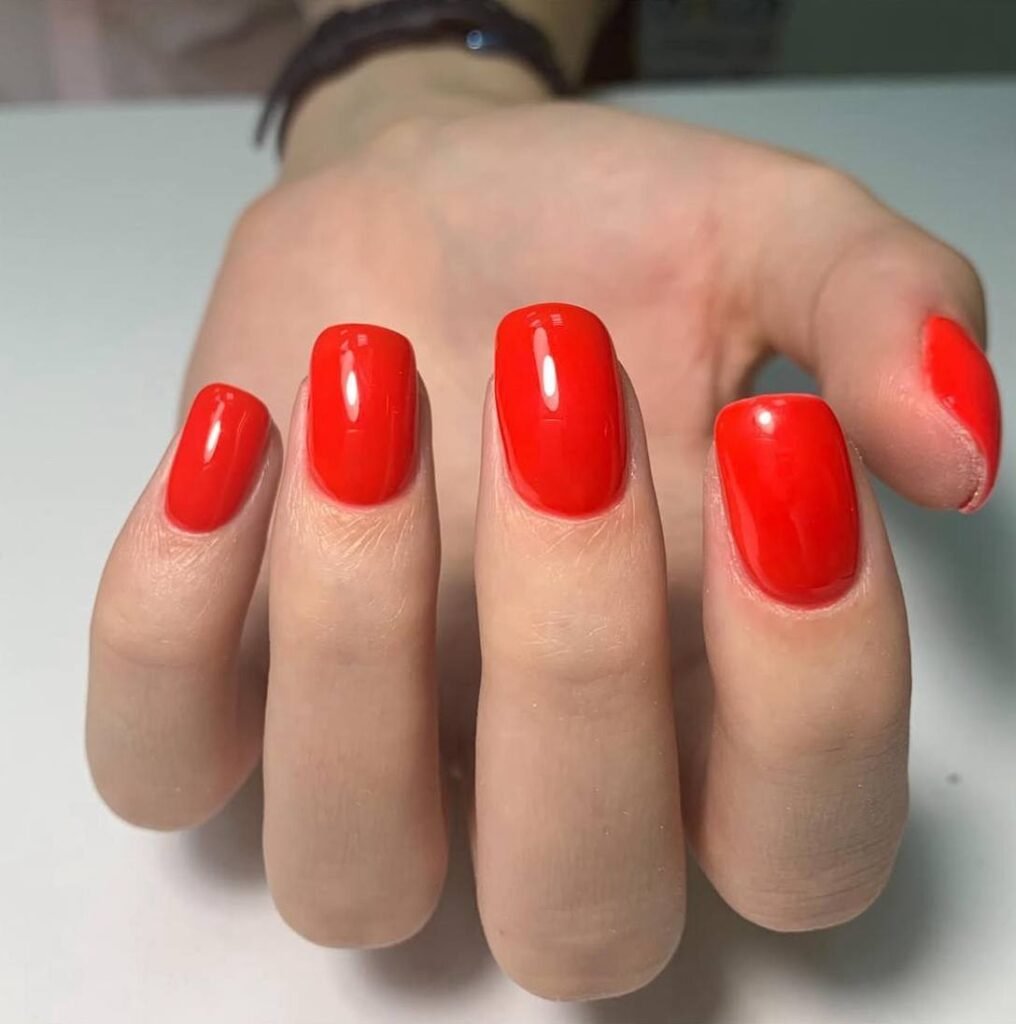 Glossy red manicure created at russian nail salon near me in Tampa, Florida with clean cuticle work.