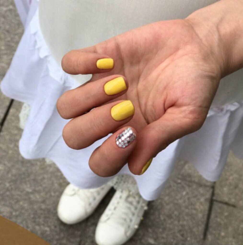 Bright yellow builder gel manicure in Tampa, Florida with glossy finish and structured shape.