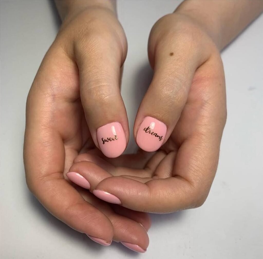 Soft pink european manicure with delicate lettering on short natural nails in Tampa, Florida.