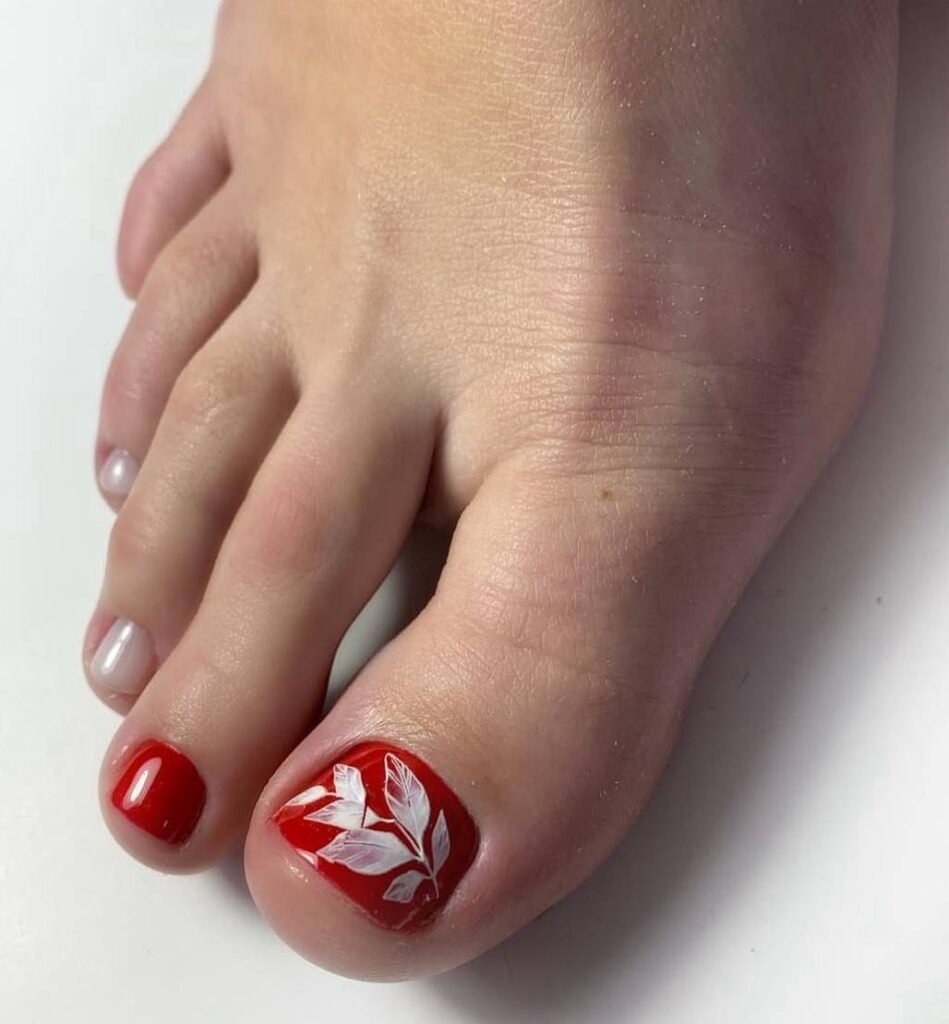 Red gel pedicure tampa design with white leaf art on toes in Tampa, Florida.