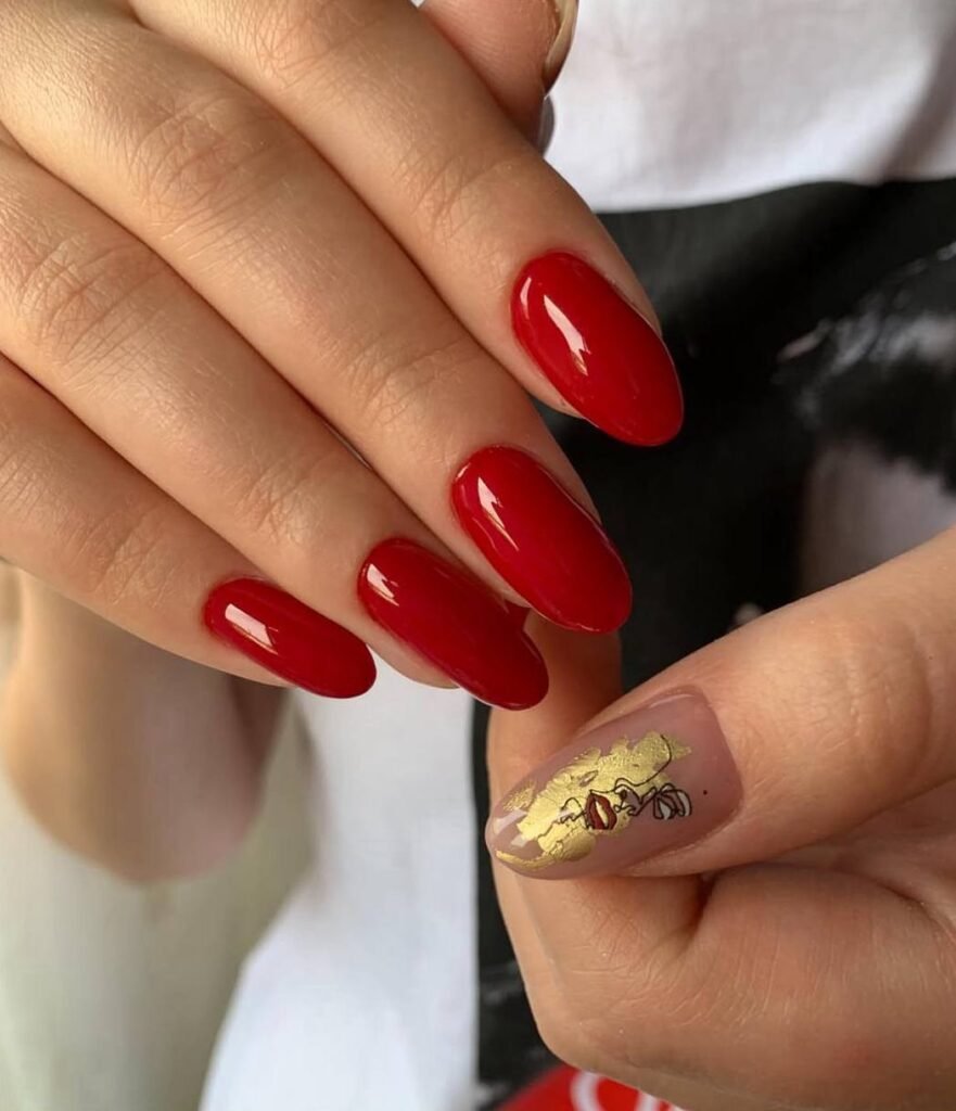 Elegant glossy red nails created at a russian manicure salon in Tampa, Florida with gold accent detail.