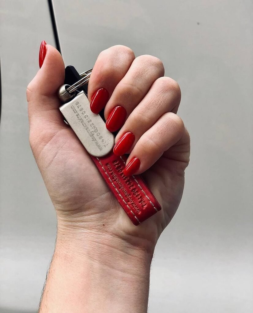 Deep glossy red manicure at russian nail salon near me in Tampa Florida holding keys close-up