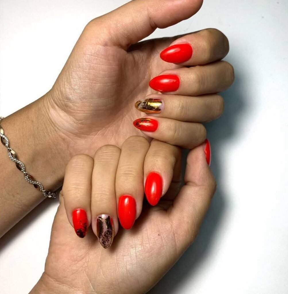 Elegant red manicure with gold accents at a russian nail salon in Tampa, Florida