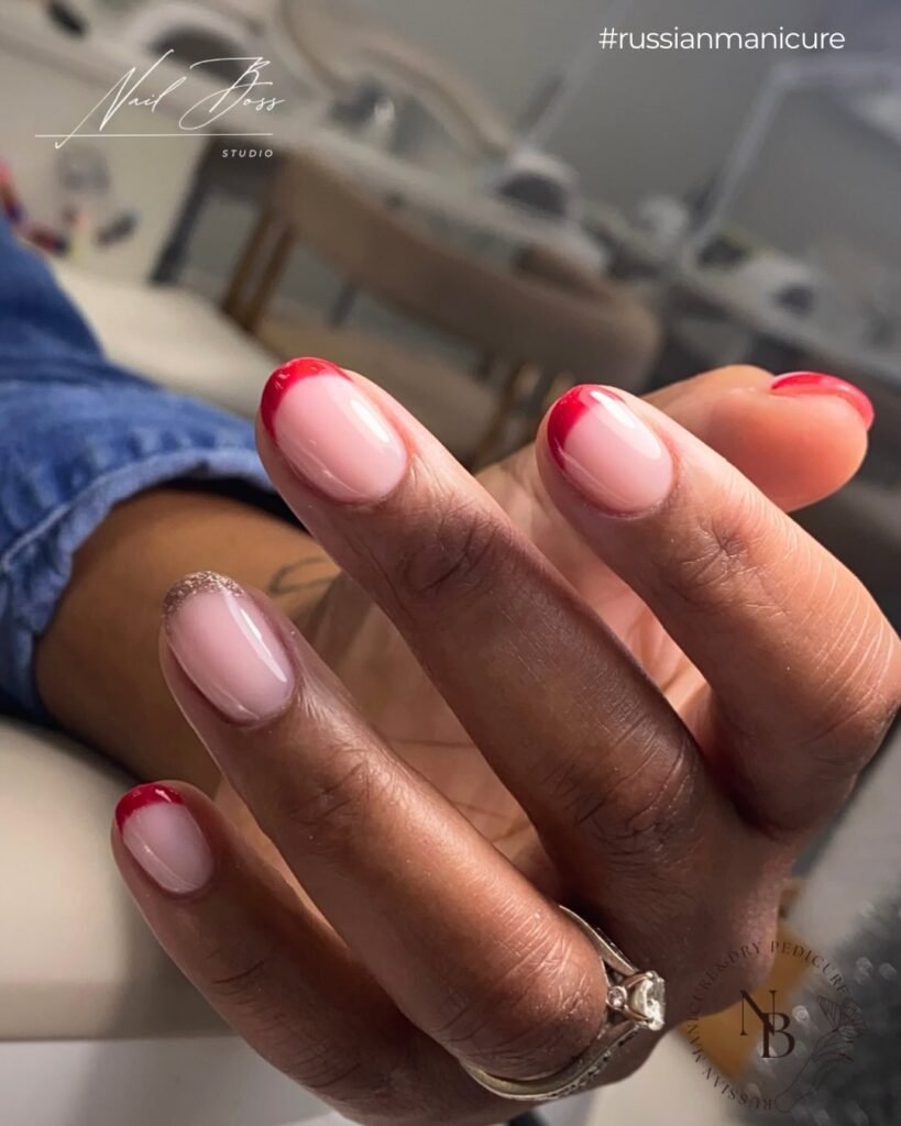 Soft pink nails with red tips created using builder gel manicure in Tampa, Florida