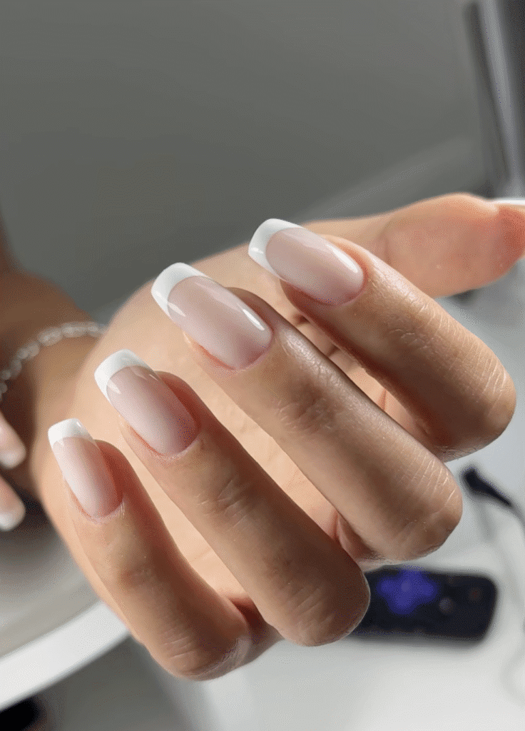Elegant soft pink builder gel manicure with French tips on natural nails in Tampa Florida