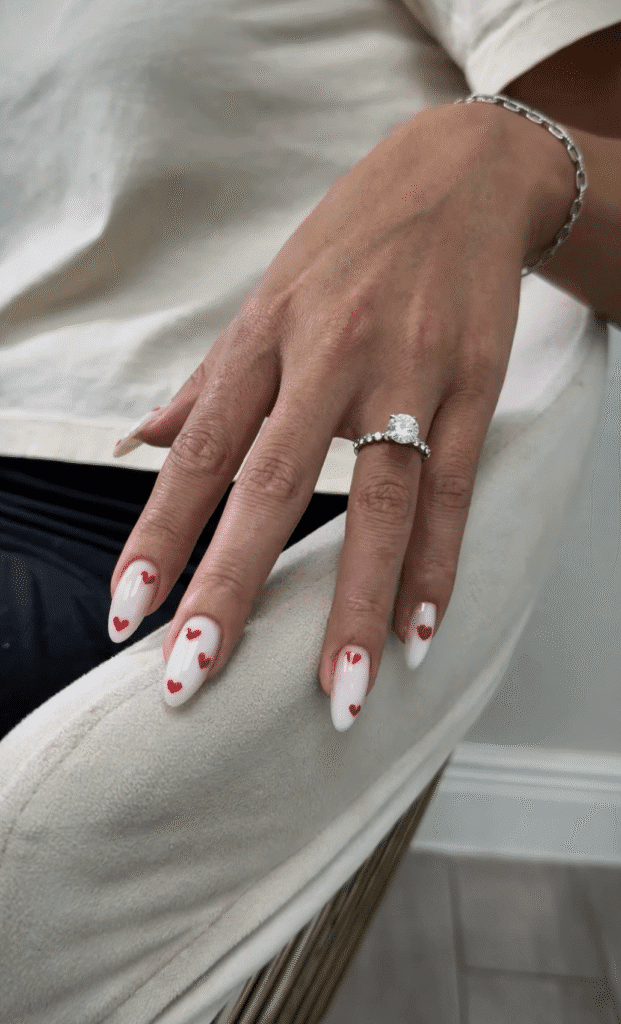 european manicure in Tampa with almond shape white nails and red heart accents