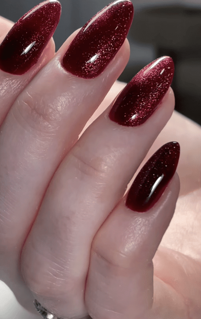 Elegant deep red almond shaped nails with shimmer created using builder gel manicure Tampa technique