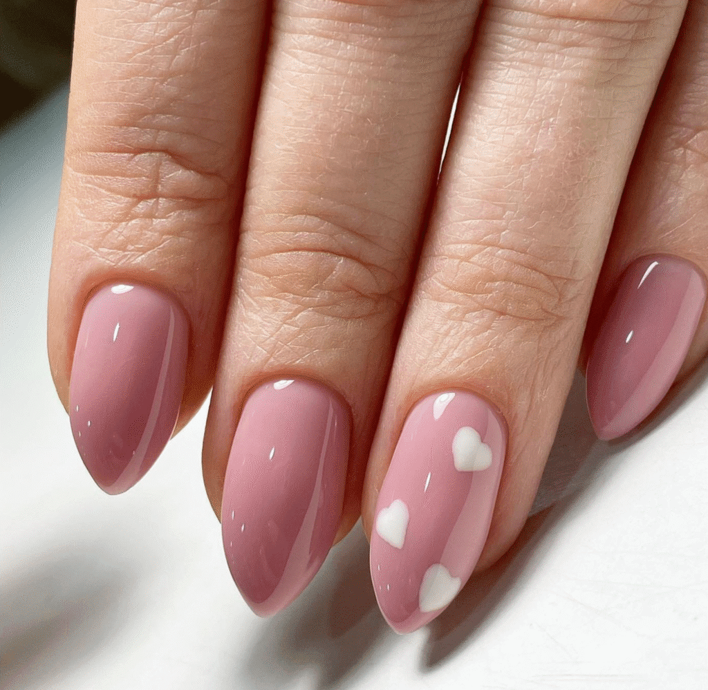 Soft pink almond nails with white heart design at a russian manicure salon in Tampa, Florida