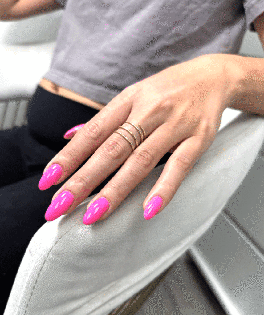 Bright pink glossy almond-shaped russian nails Tampa manicure with clean cuticles at a salon in Tampa, Florida
