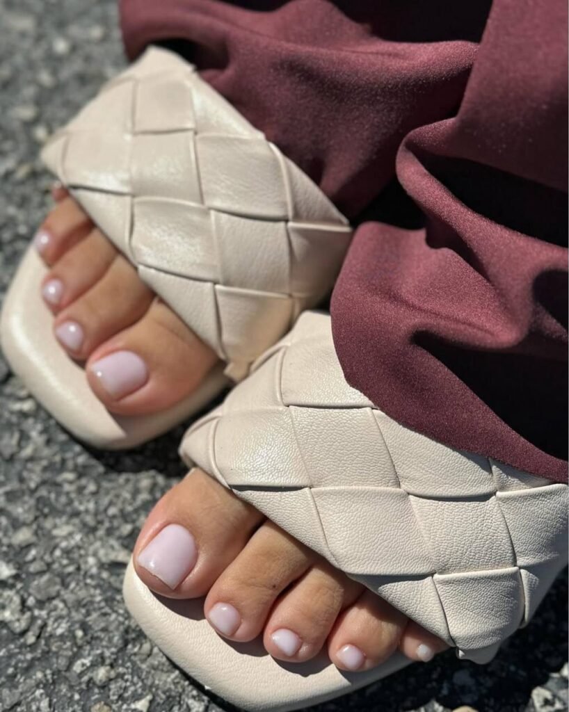 Soft clean toes after a smart pedicure in Tampa wearing woven sandals on sunlit pavement