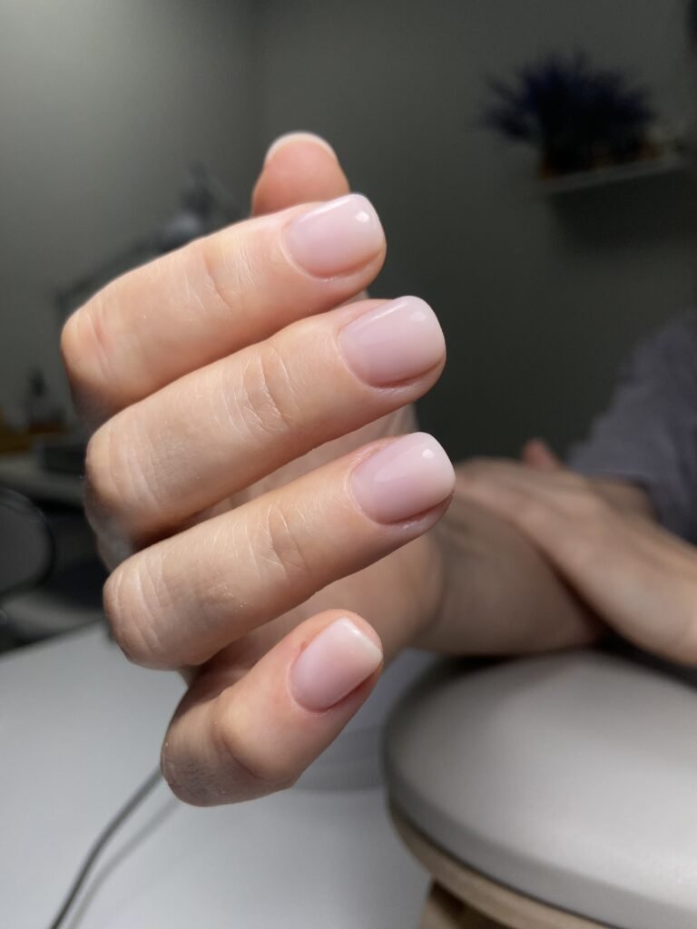 Soft pink hard gel russian manicure in Tampa, Florida with clean natural structure and glossy finish.