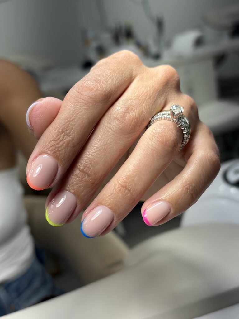 Elegant nude manicure with colorful French tips showcasing russian manicure Tampa at Nail Boss Studio Tampa, Florida.