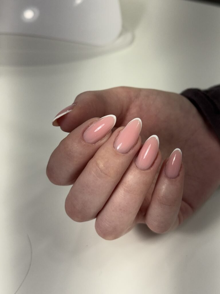 Soft pink french nails featuring a european manicure with clean cuticles and glossy finish in Tampa, Florida.