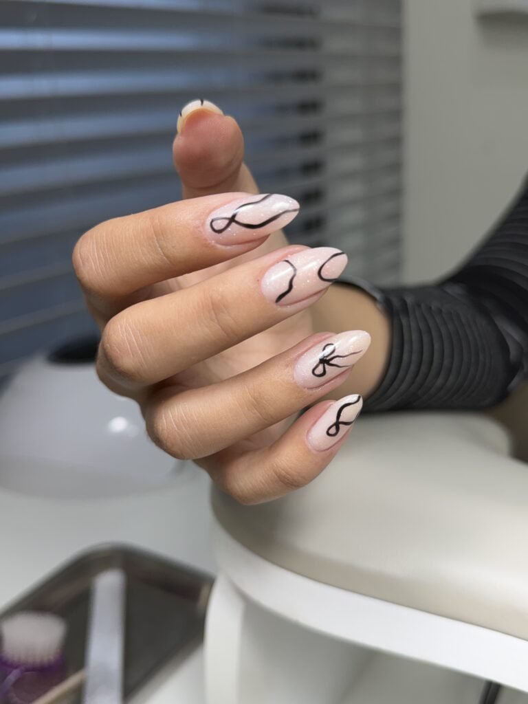 Elegant almond-shaped nails with minimalist black line art and shimmer finish, russian manicure Tampa at Nail Boss Studio Tampa.