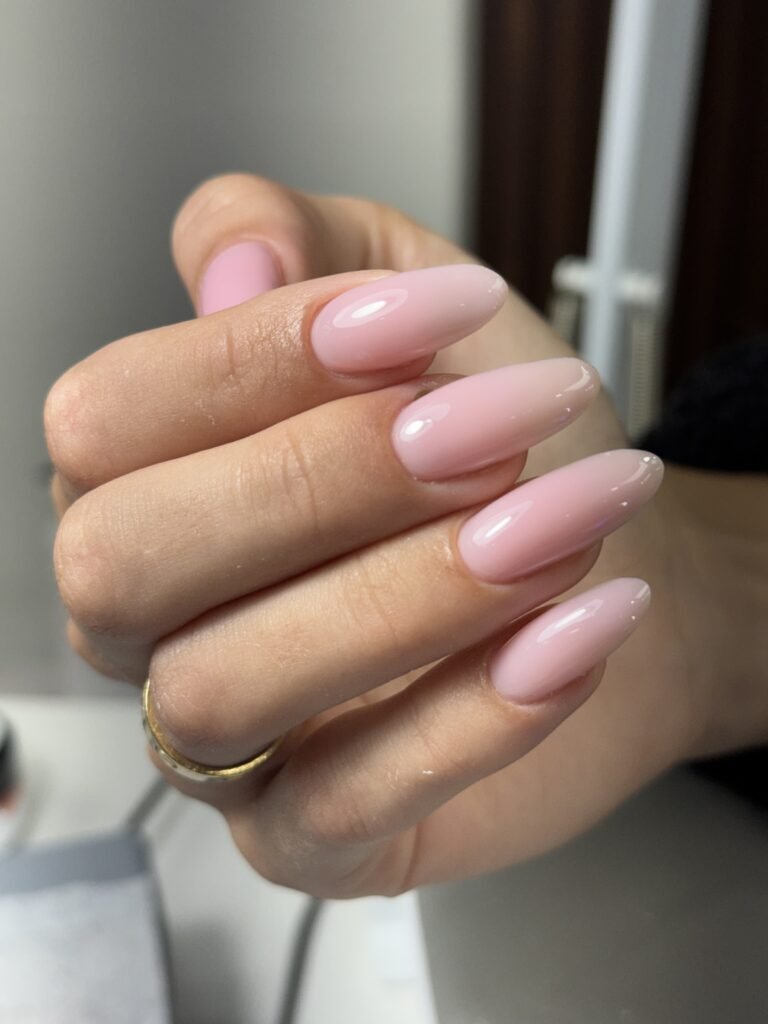 Soft pink builder gel manicure with glossy almond-shaped nails at a Tampa nail studio.