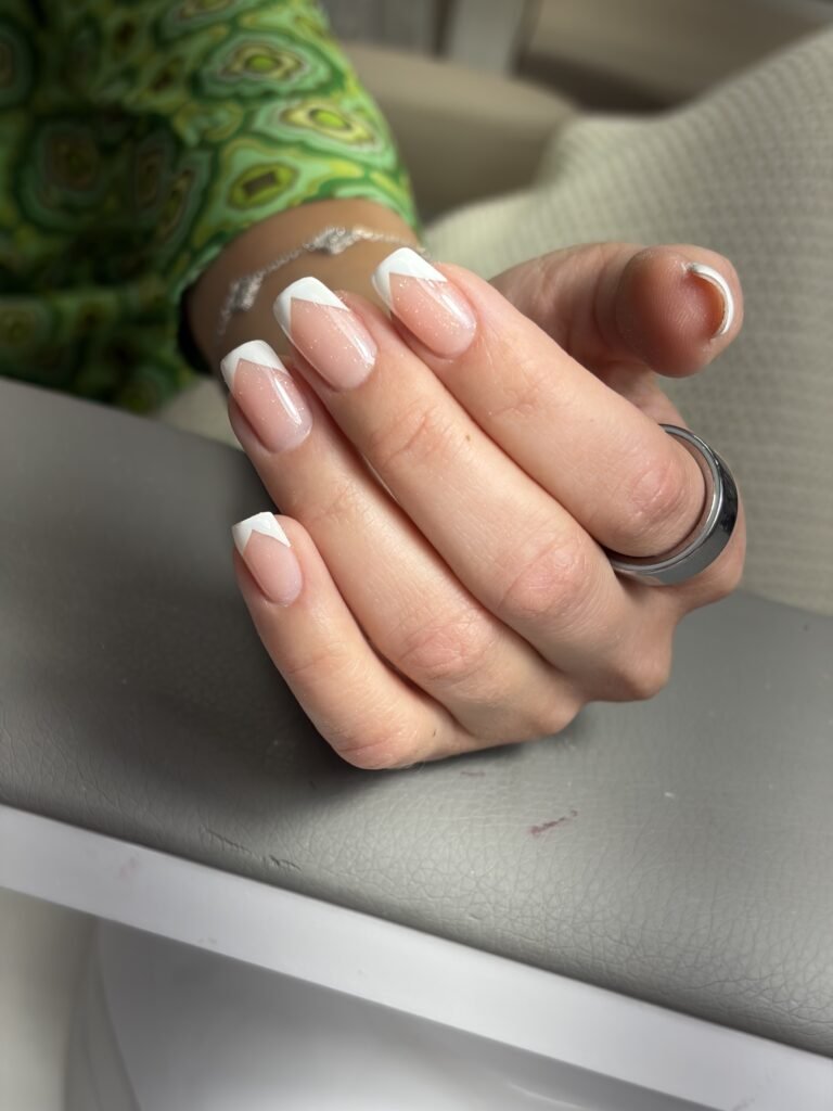 Elegant russian manicure with modern white French tips on natural builder gel nails in Tampa, Florida.