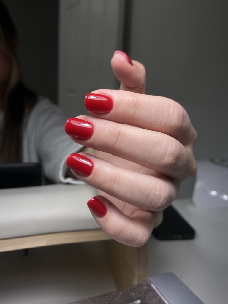 Classic glossy red russian nails tampa manicure with clean cuticles and elegant oval shape at a Tampa nail studio.