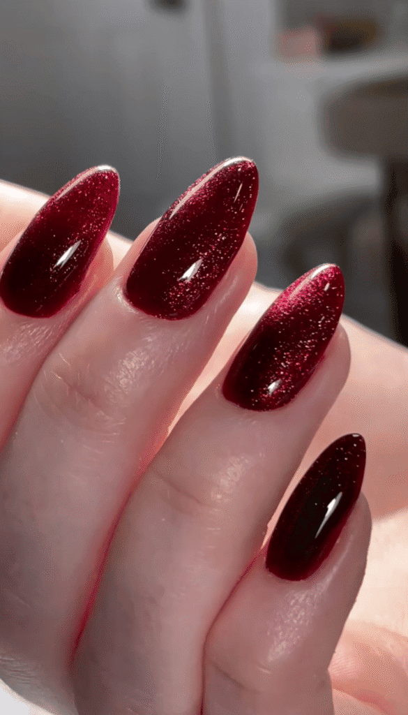 Elegant builder gel manicure in deep burgundy shimmer on almond-shaped nails in Tampa, Florida.
