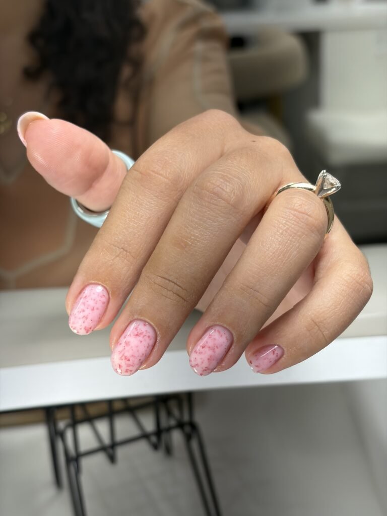 Soft pink builder gel tampa manicure with delicate pink flakes on natural nails at Nail Boss Studio in Tampa, Florida.