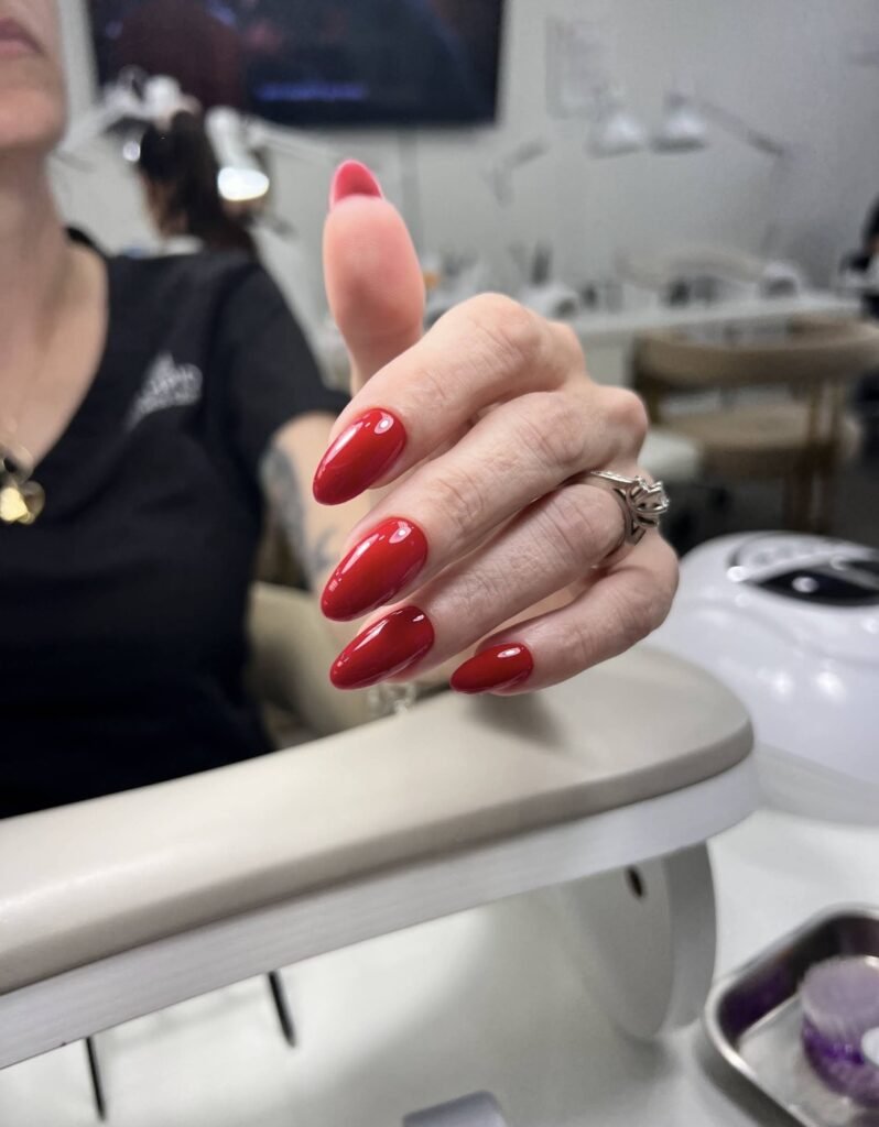 Classic glossy red almond nails featuring builder gel Tampa at Nail Boss Studio in Tampa, Florida.