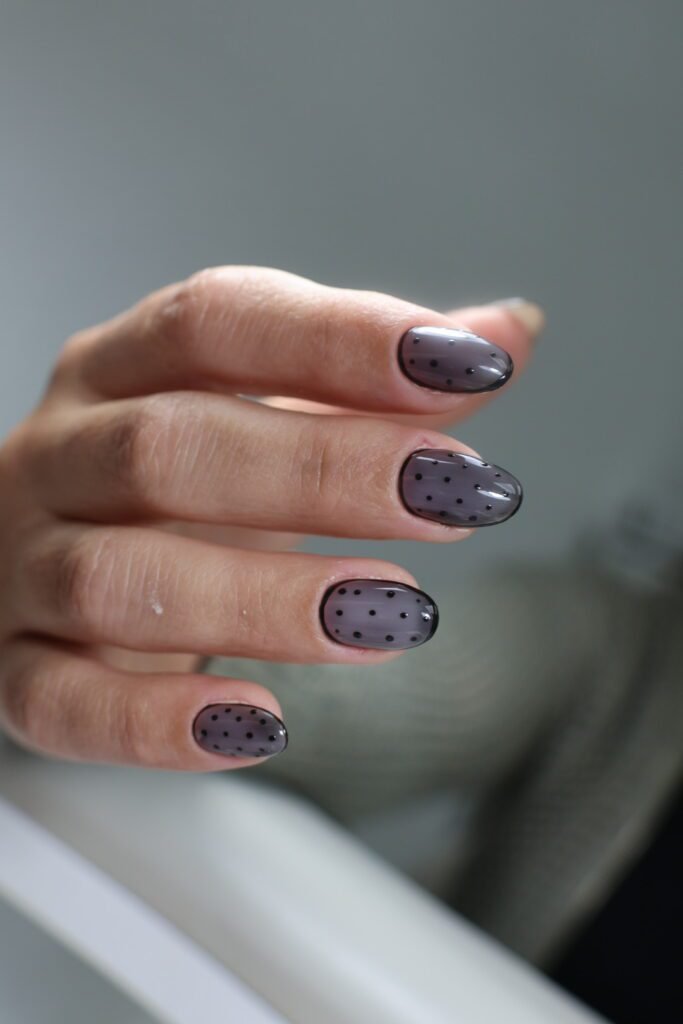 Elegant smoky gray russian manicure with delicate black polka dots on natural nails in Tampa, Florida.