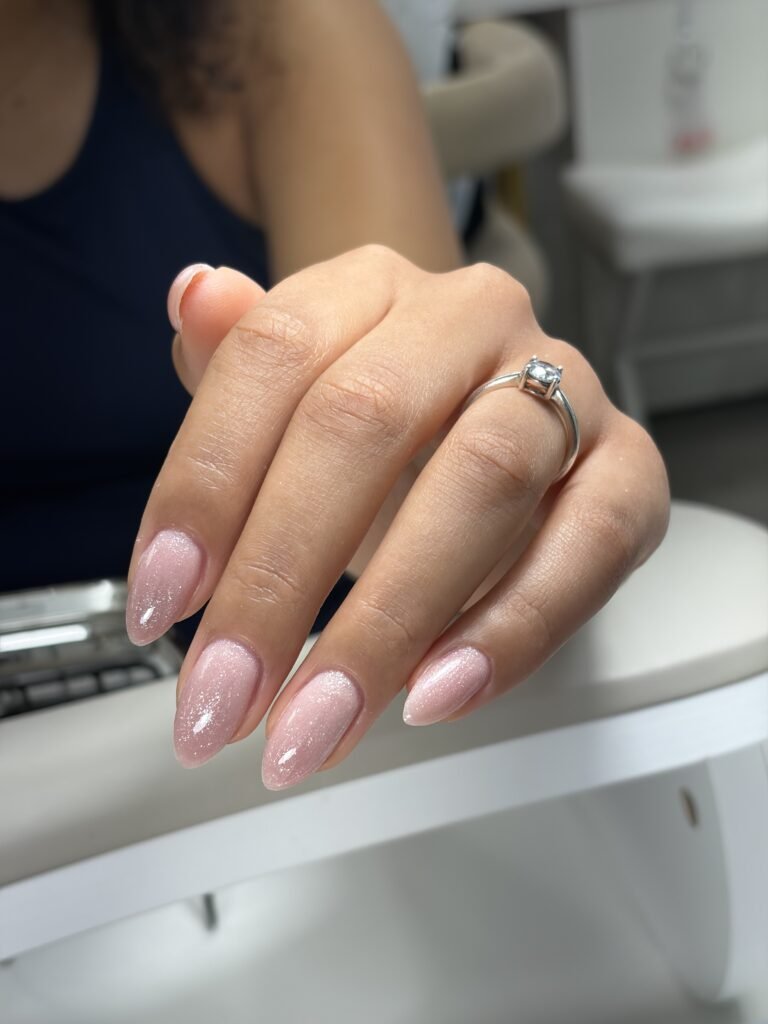 Elegant soft pink shimmer russian manicure in tampa at Nail Boss Studio Tampa, Florida with clean almond-shaped nails.