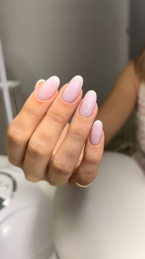 Soft pink russian manicure with delicate shimmer on natural almond nails at Nail Boss Studio Tampa, Florida.