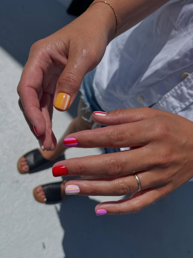 Colorful tampa russian nails manicure with red, pink, striped, and yellow accents at Nail Boss Studio Tampa, Florida.