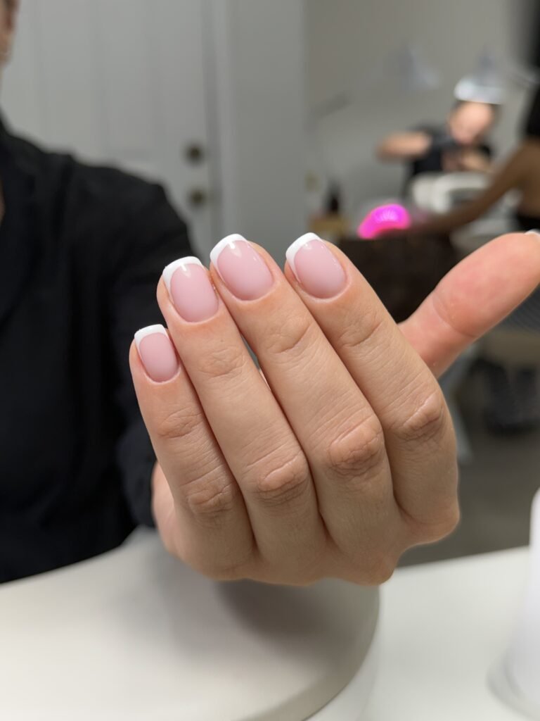 Soft pink european manicure with classic French tips on short natural nails at Nail Boss Studio Tampa, Florida.