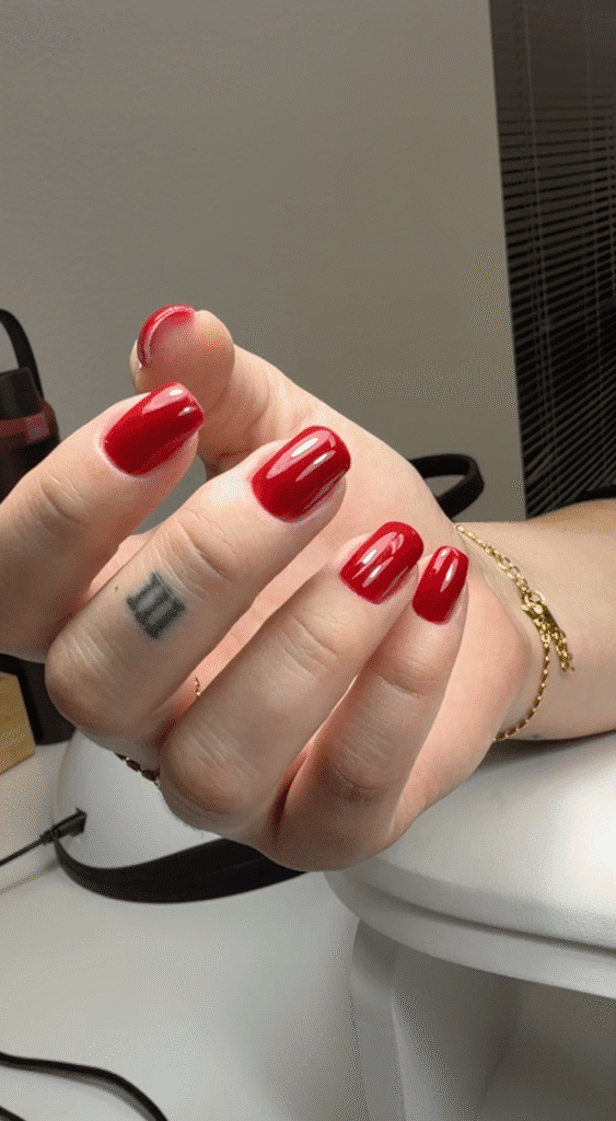 Glossy red polish on short, softly squared nails, showcasing a dry manicure look in Tampa.